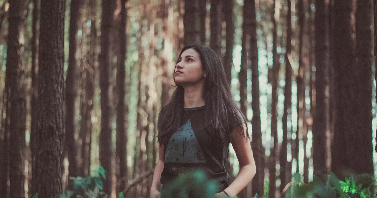 Mujer respirando tranquila en un bosque